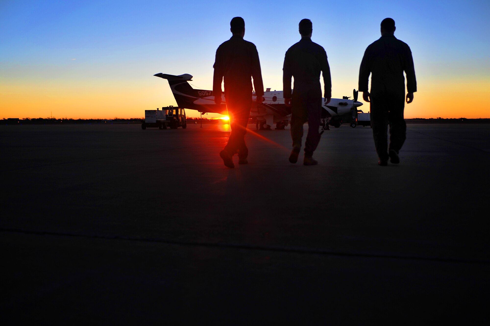 Members from the 318th Special Operations Squadron walk on the flightline to begin pre-flight operations, Dec. 5, 2014 at Cannon Air Force Base, N.M. The 318 SOS held its first Intelligence, Surveillance and Reconnaissance competition to challenge aircrew ability to complete tasks with degraded systems, meet specific time requirements, perfect communication with emphasis on brevity, practice turnovers between aircraft to maintain constant surveillance, and provide situational awareness and directions to friendly forces while navigating through urban terrain. (U.S. Air Force photo/ Senior Airman Eboni Reece)