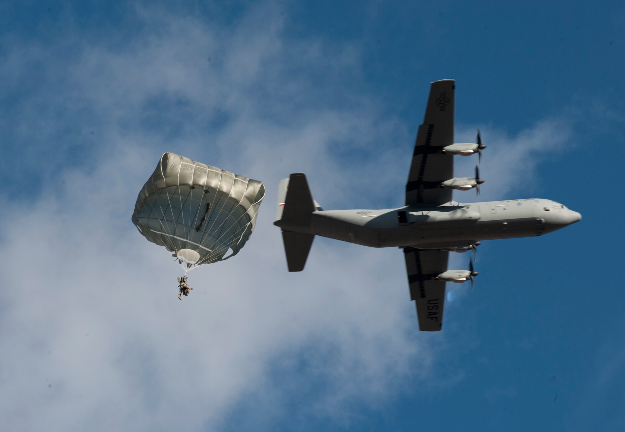 A paratrooper assigned to the 3rd Brigade Combat Team, 82nd Airborne Division, Fort Bragg, N.C., descends from a U.S. Air Force C-130 Hercules during the U.S. Air Force Weapons School's Joint Forcible Entry Exercise 14B over the Nevada Test and Training Range Dec. 6, 2014. JFEX exercises are held twice annually to maintain rapid deployment capabilities between Army and Air Force assets. (U.S. Air Force photo by Airman First Class Joshua Kleinholz)