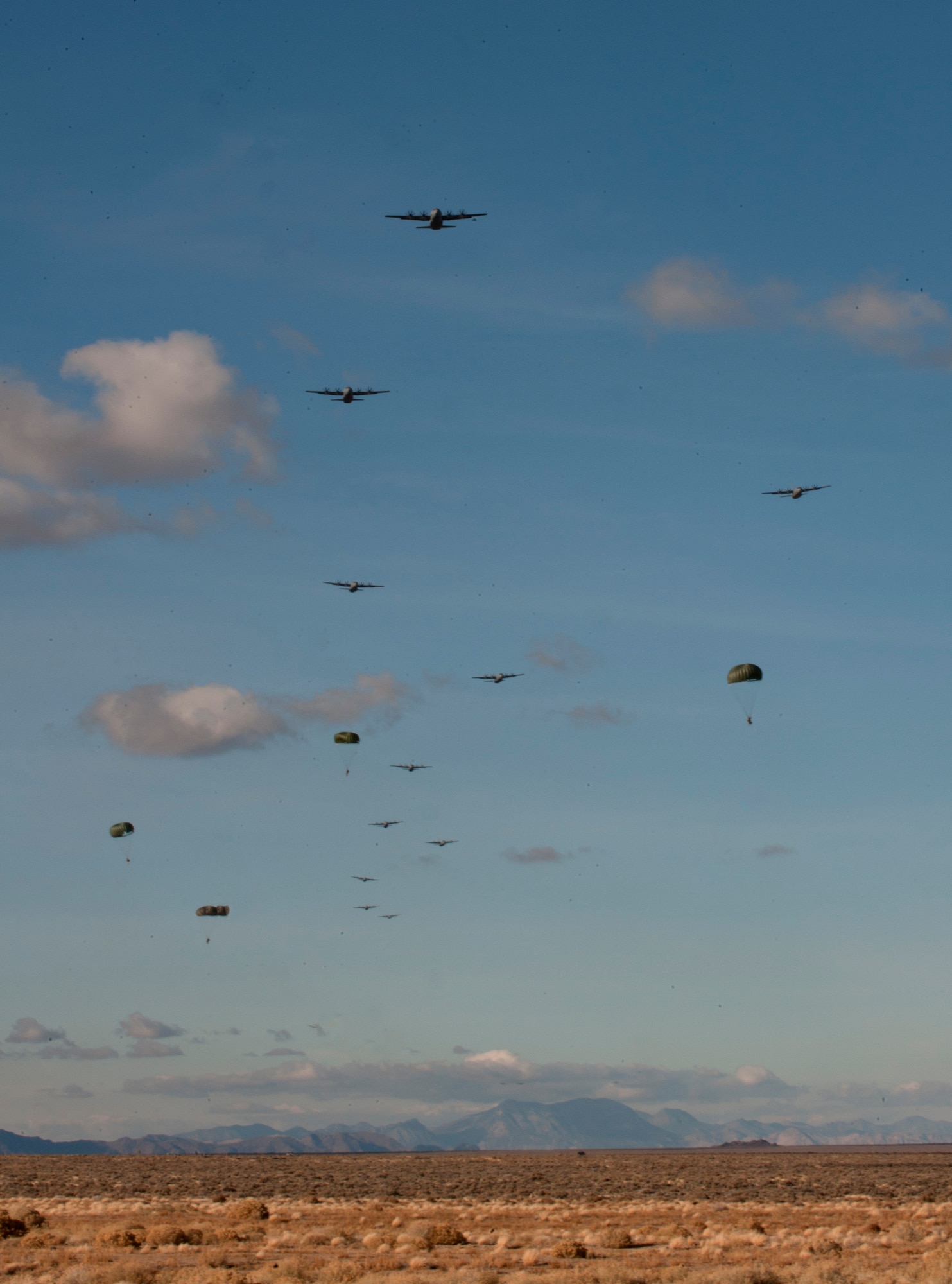 Paratroopers assigned to the 3rd Brigade Combat Team, 82nd Airborne Division, Fort Bragg, N.C., jump from C-17 Globemaster IIIs and C-130 Hercules during the U.S. Air Force Weapons School's Joint Forcible Entry Exercise 14B on the Nevada Test and Training Range, Dec. 6, 2014. JFEX, a USAF Weapons School large-scale air mobility exercise, challenges students to plan and execute a complex air-land operation in a simulated contested battlefield. (U.S. Air Force photo by Staff Sgt. Victoria Sneed)