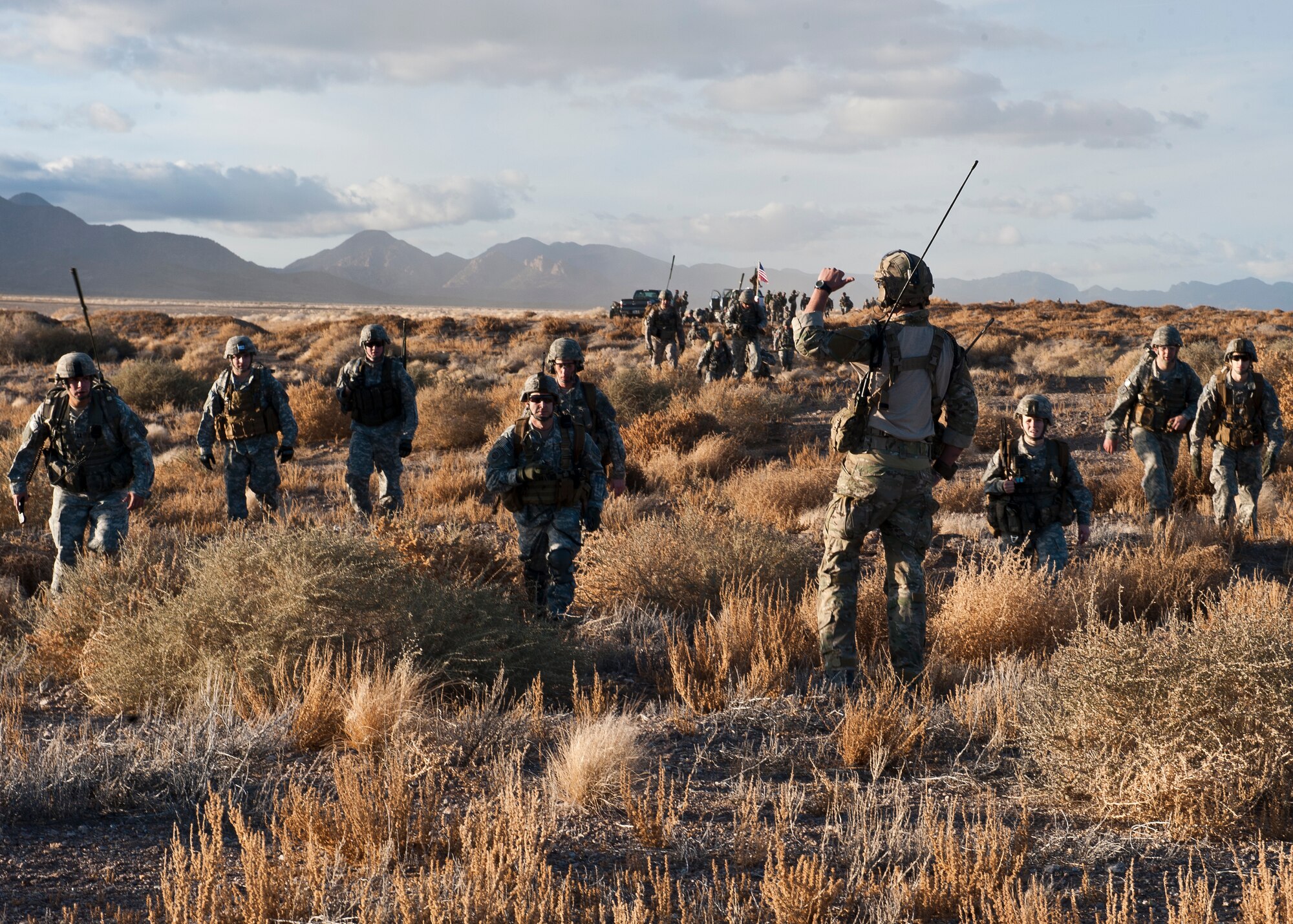 A Joint Terminal Attack Controller directs paratroopers assigned to the 3rd Brigade Combat Team, 82nd Airborne Division, Fort Bragg, N.C., to their rally point during the U.S. Air Force Weapons School's Joint Forcible Entry Exercise 14B on the Nevada Test and Training Range, Dec. 6, 2014. Paratroopers jumped from multiple C-17 Globemaster IIIs and C-130 Hercules to secure a simulated airfield. (U.S. Air Force photo by Staff Sgt. Victoria Sneed)