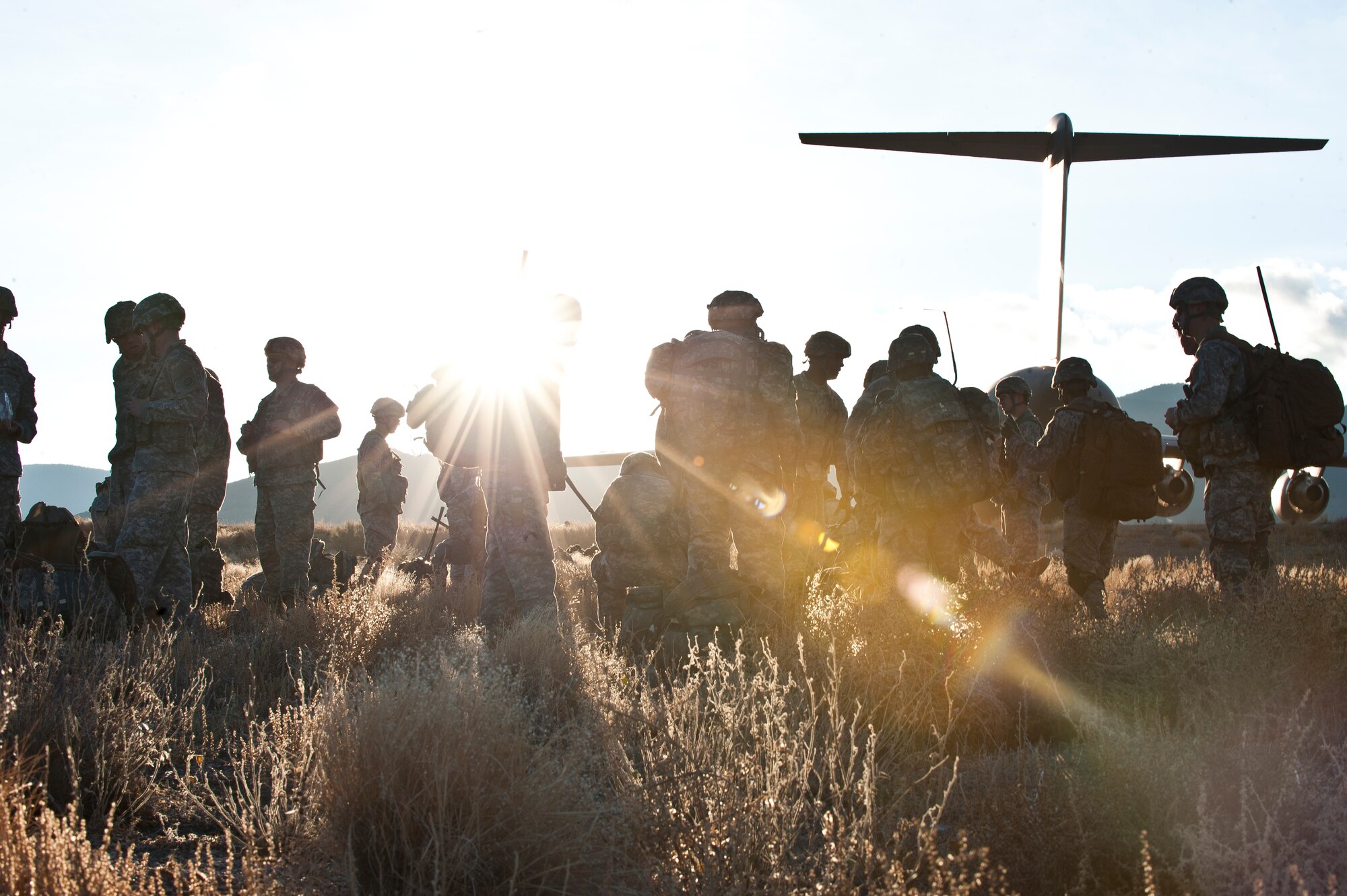 Paratroopers assigned to 3rd Brigade Combat Team, 82nd Airborne Division, Fort Bragg, N.C., gather at their rally point during the U.S. Air Force Weapons School's Joint Forcible Entry Exercise 14B on the Nevada Test and Training Range Dec. 6, 2014. Weapons school students must synchronize aircraft movements from geographically separated bases, command large formations of dissimilar aircraft in high-threat airspace, and tactically deliver and recover combat forces via air drops and combat landings on an unimproved landing strip. (U.S. Air Force photo by Staff Sgt. Victoria Sneed)