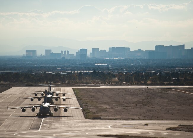 Three U.S. Air Force C-17 Globemaster IIIs taxi off the runway during the U.S. Air Force Weapons School's Joint Forcible Entry Exercise 14B at Nellis Air Force Base, Nev., Dec. 6, 2014. JFEX 14B was a joint exercise with the U.S. Army’s 82nd Airborne Division, Fort Bragg, N.C. (U.S. Air Force photo by Airman 1st Class Mikaley Towle)