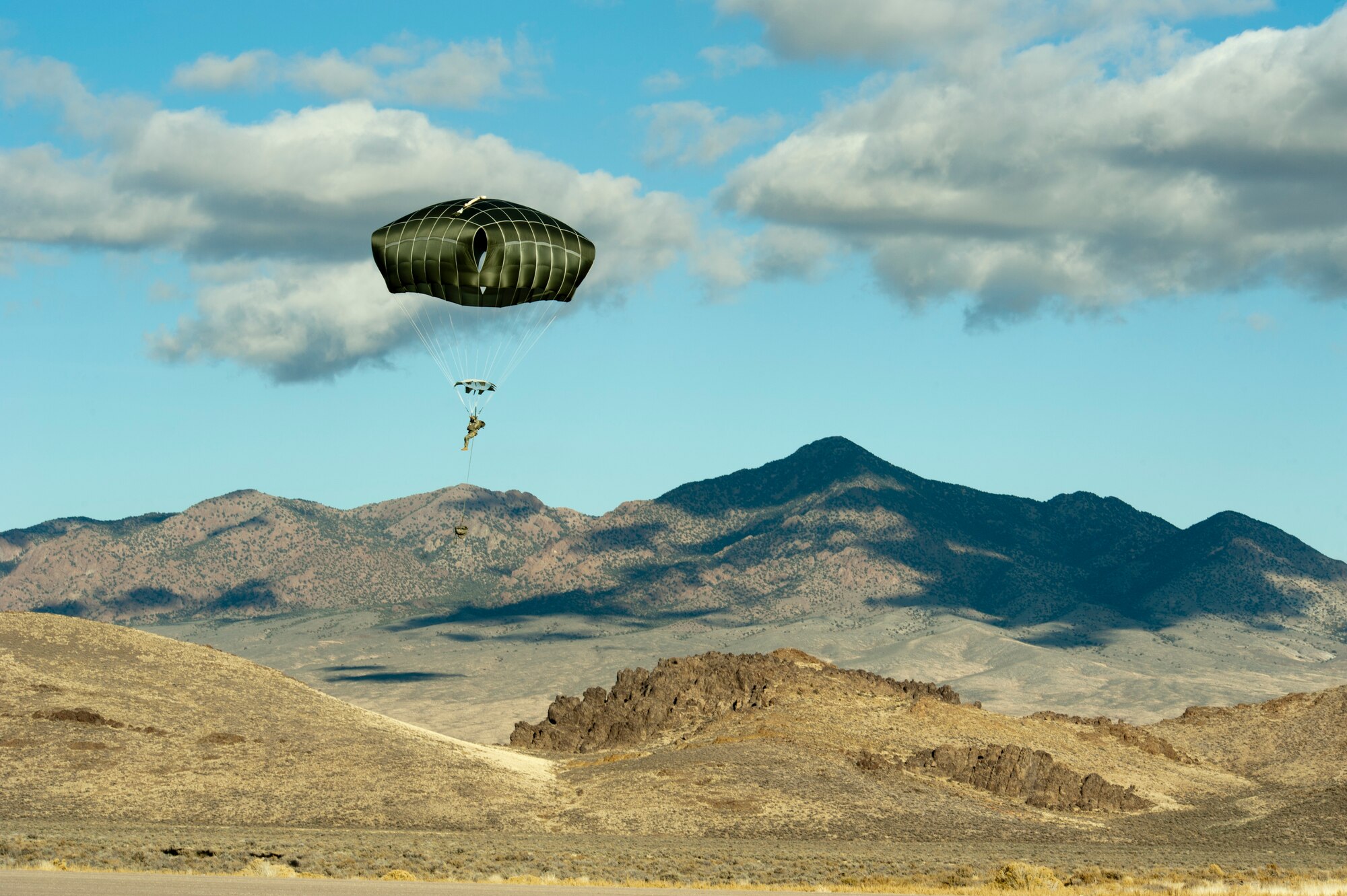 A paratrooper assigned to the 3rd Brigade Combat Team, 82nd Airborne Division, Fort Bragg, N.C., comes in to land during the U.S. Air Force Weapons School's Joint Forcible Entry Exercise 14B over the Nevada Test and Training Range Dec. 6, 2014. JFEX is a USAF Weapons School large-scale air mobility exercise in which participants plan and execute a complex air-land operation in a simulated contested battlefield. (U.S. Air Force photo by Senior Airman Timothy Young)