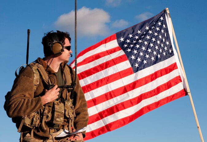 A Joint Terminal Attack Controller observes aircraft and personnel movement during the U.S. Air Force Weapons School's Joint Forcible Entry Exercise 14B on the Nevada Test and Training Range Dec. 6, 2014. More than 100 paratroopers and approximately 100 aircraft participated in the exercise as part of the USAFWS’ large-scale air mobility exercise to train students to contribute strategically to a joint operation. (U.S. Air Force photo by Staff Sgt. Victoria Sneed)