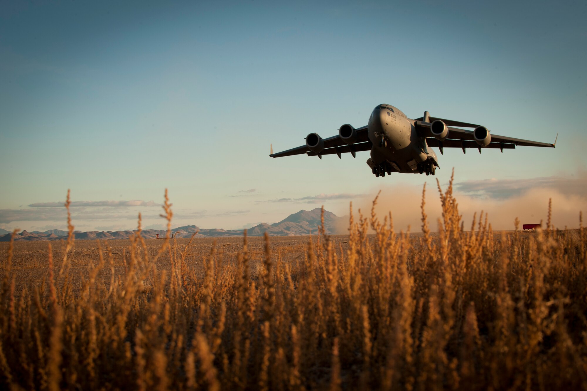A U.S. Air Force C-17 Globemaster III assigned to March Air Reserve Base, Calif., takes off from a degraded airfield during the U.S. Air Force Weapons School's Joint Forcible Entry Exercise 14B at the Nevada Test and Training Range Dec. 6, 2014. JFEX exercises participants' ability to synchronize aircraft movements from geographically-separated bases, command large formations of dissimilar aircraft in high-threat airspace and tactically deliver and recover combat forces via air drops and combat landings on an unimproved landing strip. (U.S. Air Force photo by Airman First Class Joshua Kleinholz)