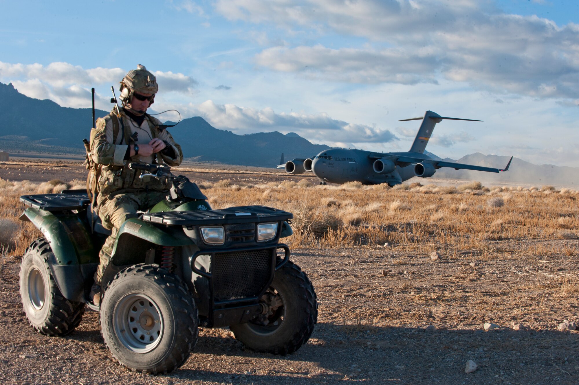 A Joint Terminal Attack Controller prepares to guide paratroopers to a rally point after a C-17 Globemaster III lands an unimproved landing strip during the U.S. Air Force Weapons School's Joint Forcible Entry Exercise 14B on the Nevada Test and Training Range Dec. 6, 2014. The JFEX, as part of a restructured integration phase in the USAFWS, is a prime example of the advanced training these students receive throughout this course that is unmatched anywhere else in the world. (U.S. Air Force photo by Staff Sgt. Victoria Sneed)