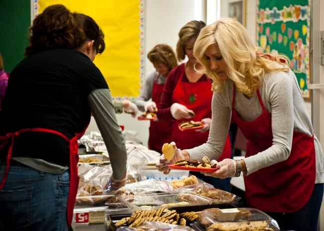 Leslie Boutwell, wife of Col. Richard Boutwell, 99th Air Base Wing commander, sorts baking dishes filled with home baked cookies to be delivered to single Airmen at the base chapel on Nellis Air Force Base, Nev., Dec. 8, 2014. The Nellis Area Spouses’ Club collected more than 15,000 cookies donated by the base populace, organizations around the base and the local community for Airmen residing in the base dormitories.  (U.S. Air Force photo by Airman 1st Class Mikaley Towle)