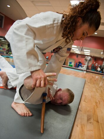 Judith applies pressure to her husband, Robert McIntosh’s wrist, causing him to release his simulated weapon during the Nesei Bujutsu class at the Warrior Fitness Center on Nellis Air Force Base, Nev., Dec. 9, 2014. Students are taught to use pressure points and small joint pressure to cause assailants to release weapons while also subduing them.(U.S. Air Force photo by Staff Sgt. Victoria Sneed)