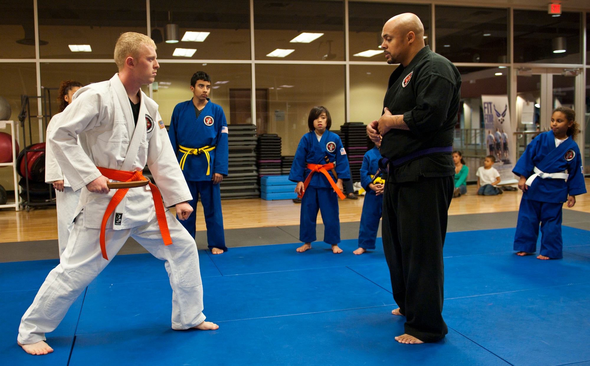 Renshi DeAndre Scott (black gi) instructs Robert McIntosh, 99th Civil Engineer Squadron, where to aim his wooden knife during the disarming portion of the Nesei Bujutsu class at the Warrior Fitness Center on Nellis Air Force Base, Nev., Dec. 9, 2014. Students are taught to use holds and pressure points to subdue and disarm attackers, regardless of size. (U.S. Air Force photo by Staff Sgt. Victoria Sneed)