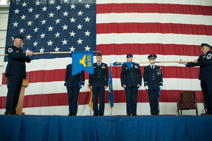 The 926th Group’s guidon is furled, before it is cased, as the Wing guidon is unfurled and brought into service during the 926th Wing activation ceremony Dec. 5, 2014, at Nellis Air Force Base, Nev. The redesignation ceremony took place before a crowd of total force Airmen who trace their wing’s roots back to 1963 when the 926th Troop Carrier Group was established at Naval Air Station Joint Reserve Base New Orleans, La., where they flew the C-119 Flying Box Car. (U.S. Air Force photo by Senior Airman Timothy Young)