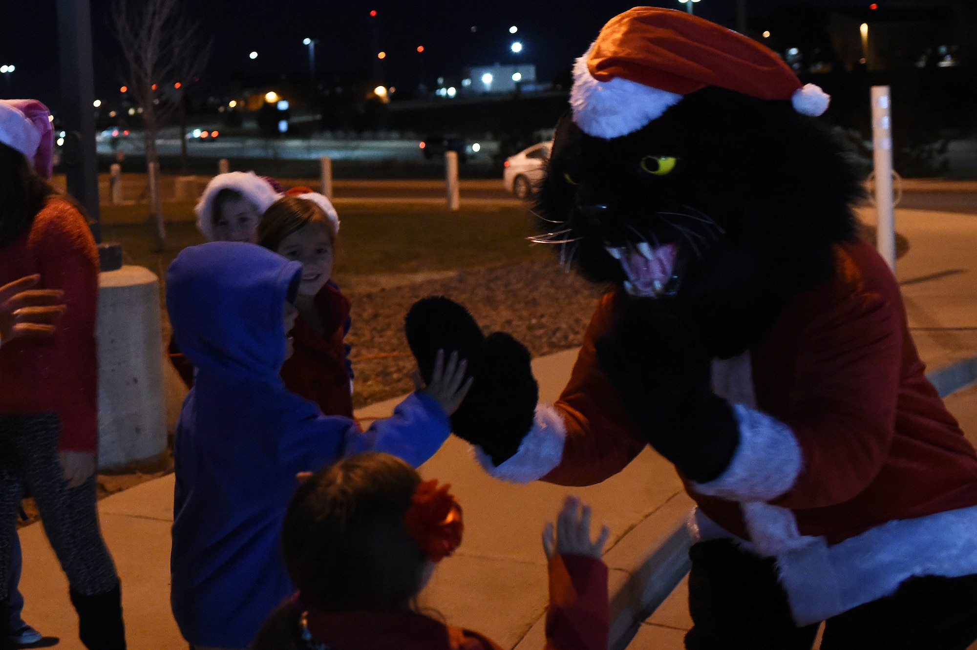 Team Buckley children high-five the 460th Space Wing mascot, Buck Lee, dressed as Santa Claus, during a tree-lighting ceremony Dec. 9, 2014, at the 460th SW headquarters building on Buckley Air Force Base, Colo. The annual tree lighting concluded with hot chocolate and cookies. (U.S. Air Force photo by Airman 1st Class Samantha Saulsbury/Released)