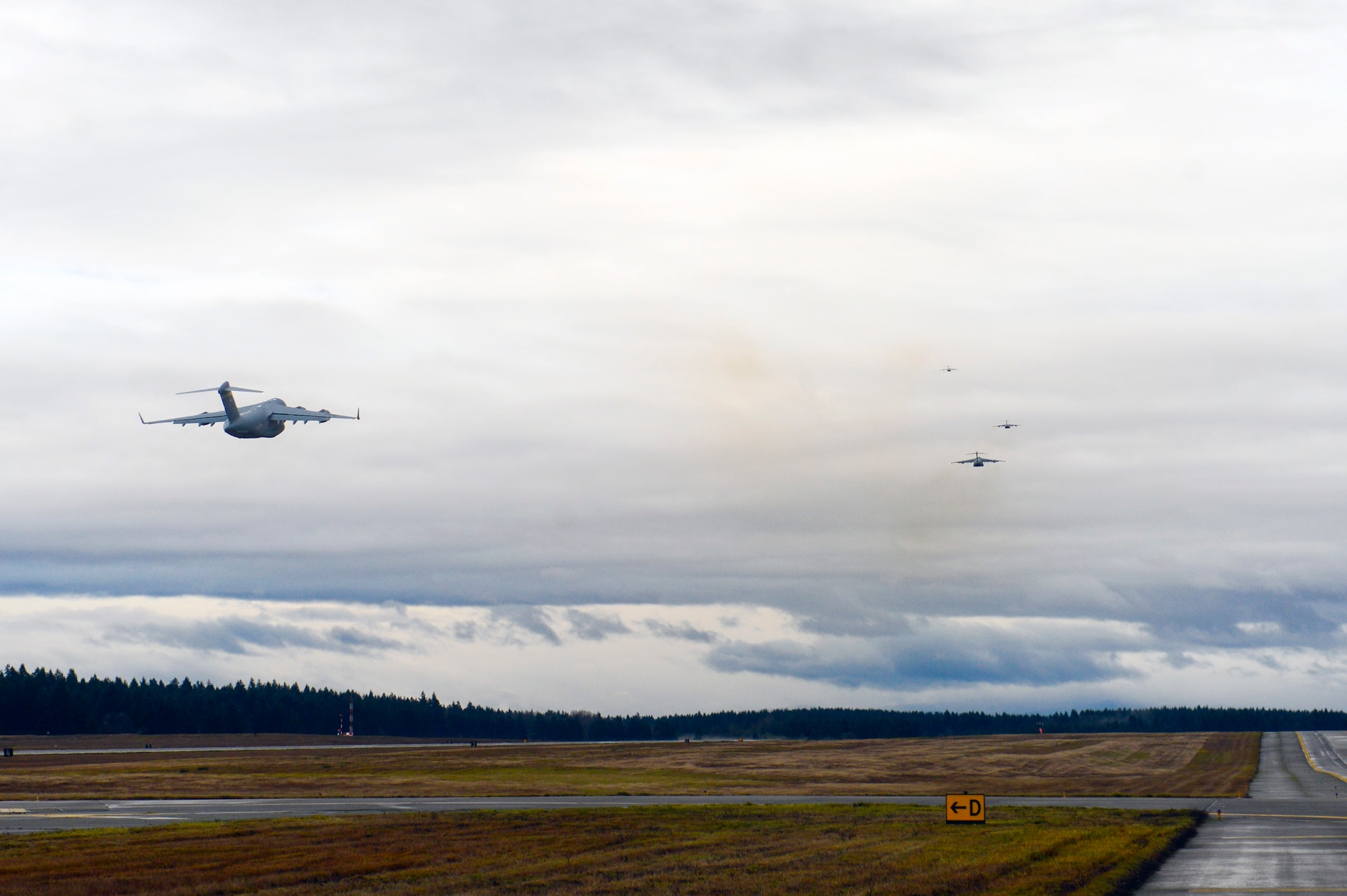 C-17 Globemaster III aircraft from Joint Bases Lewis-McChord, Pearl Harbor-Hickam, Elmendorf-Richardson take off in order to form a five-ship formation Dec. 6, 2014, from JBLM in support of a joint forcible entry exercise. Aircrews departed from McChord Field in five C-17’s to participate in realistic and complex training the Air Force has to offer. (U.S. Air Force photo/Airman 1st Class Keoni Chavarria)