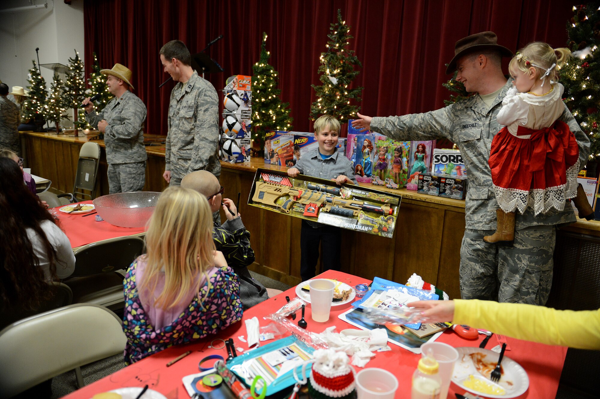 A child walks away with his new toy that he won Dec. 8, 2014, during a deployed family dinner at the Chapel Support Center on Joint Base Lewis-McChord, Wash. Families won several prizes such as soccer and basketballs, nerf guns, dolls, and board games. (U.S. Air Force photo/Airman 1st Class Keoni Chavarria)