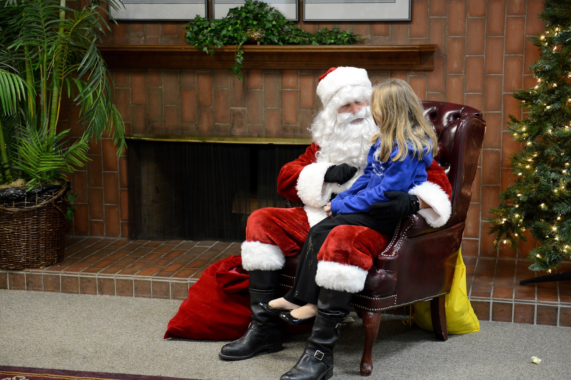 Santa Claus sits with a child as she tells him what she wants for Christmas Dec. 8, 2014, during the McChord Field Annual Tree Lighting ceremony at Joint Base Lewis-McChord, Wash. The children were able to take photos with Santa for the parents to keep. (U.S. Air Force photo/Airman 1st Class Keoni Chavarria)