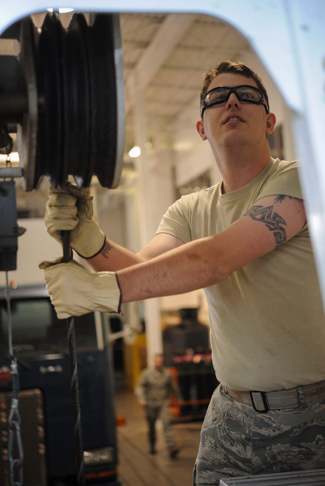 Senior Airman Alex Greenlees, 91st Missile Operations Squadron mechanical and pneudraulics section team chief, waits for instructions from his teammate during maintenance on a crane on Minot Air Force Base, N.D. Oct. 30, 2014. Greenlees adjusted tension as he and his teammates replaced the cranes old cable. (U.S. Air Force photo/Senior Airman Stephanie Morris)