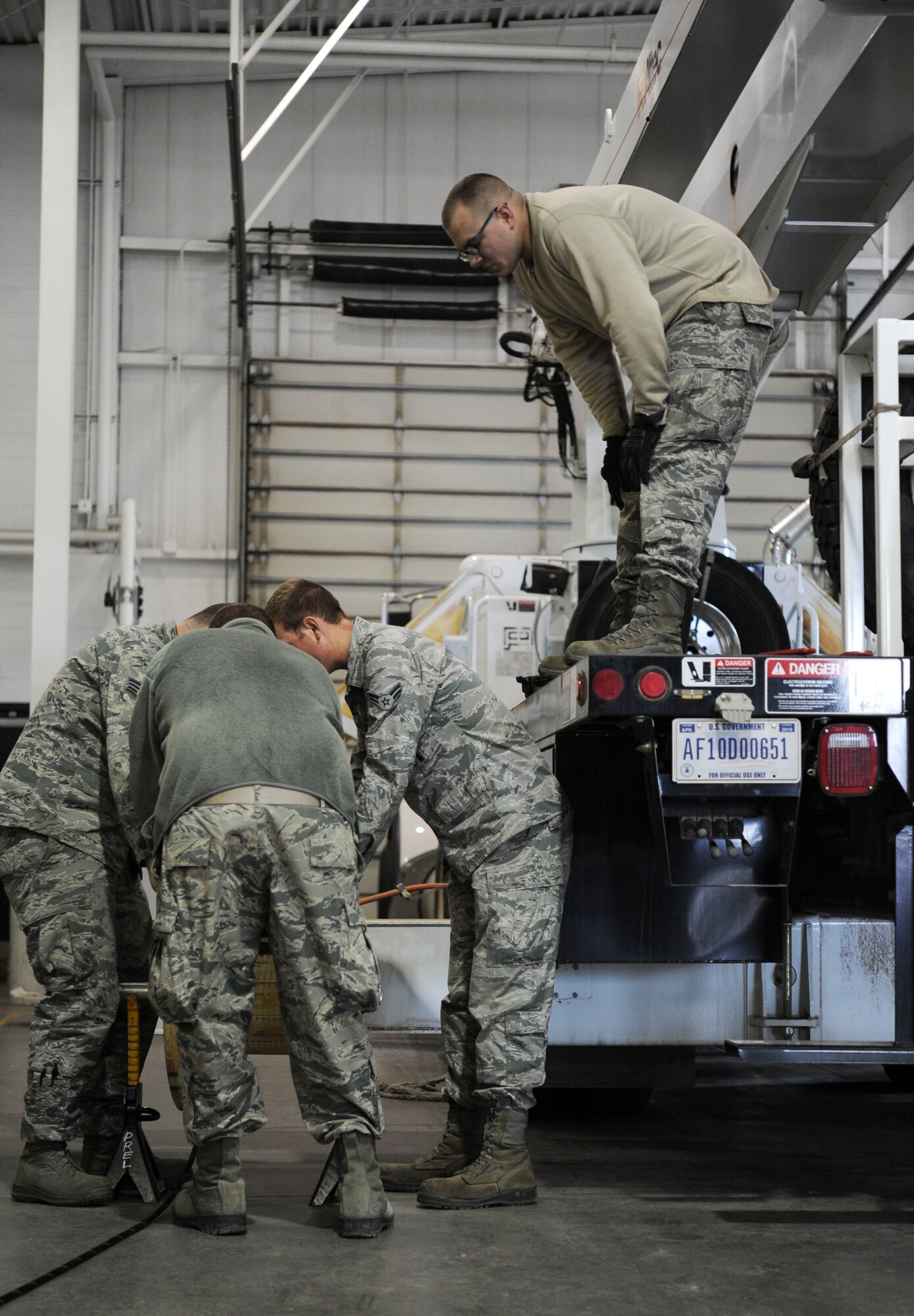A group of 91st Missile Operations Squadron mechanical and pneudraulics section team members position stabilizers during maintenance on a crane on Minot Air Force Base, N.D. Oct. 30, 2014. Stabalizers ensure  the large piece of equipment is unable to shift during maintenance. (U.S. Air Force photo/Senior Airman Stephanie Morris)