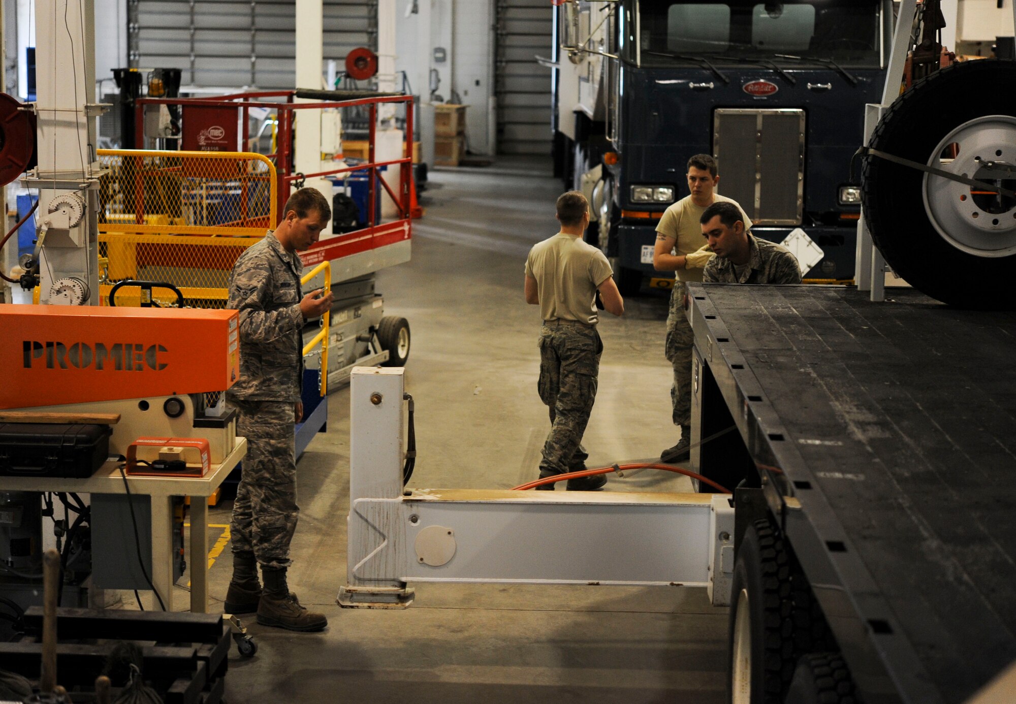 A group of 91st Missile Operations Squadron mechanical and pneudraulics section team members position stabilizers during maintenance on a crane on Minot Air Force Base, N.D. Oct. 30, 2014. Stabalizers ensure the large piece of equipment is unable to shift during maintenance. (U.S. Air Force photo/Senior Airman Stephanie Morris)