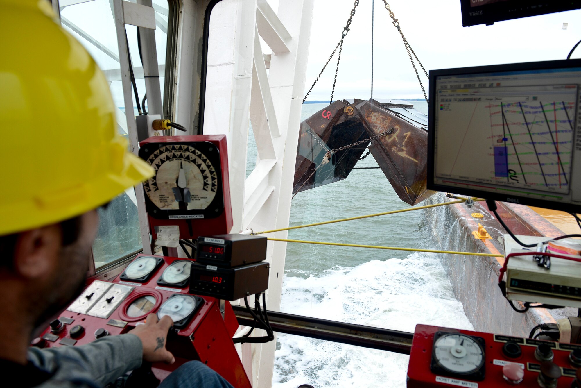 Corbin Singleton, crane operator, controls a spud-barge mounted crane at Fort Eustis, Va., Dec. 9, 2014. Dredging is the process of removing sediment and debris from the bottom of harbors, rivers and other bodies of water. (U.S. Air Force photo by Senior Airman Kimberly Nagle/Released)