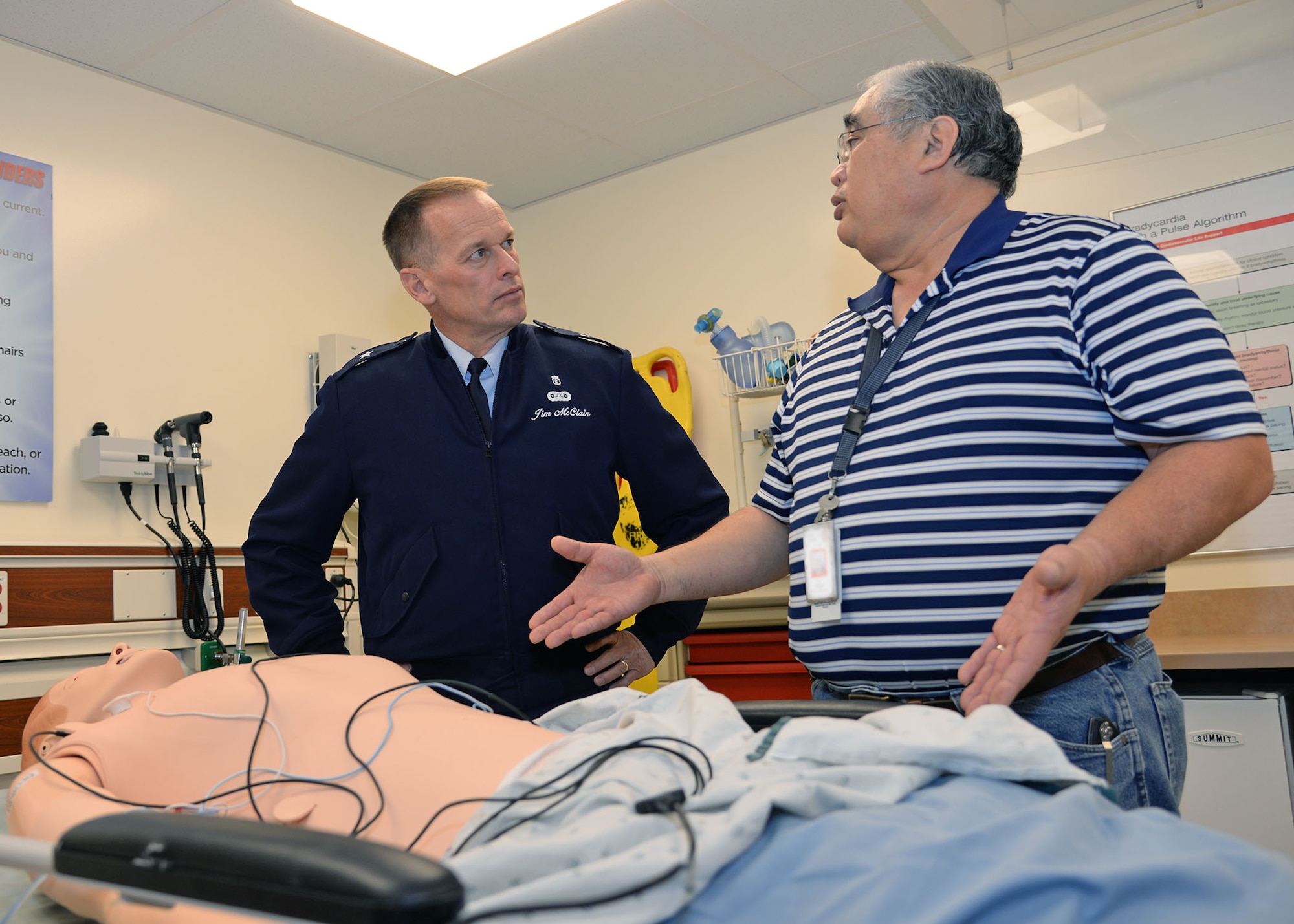 Thomas Kai, Graduate Medical Education coordinator for simulation, explains to Brig. Gen. James McClain, Air Force Medical Support Agency commander, the advanced capabilities of simulation training dummies and scenarios that are available to students at the San Antonio Military Medical Center, Joint Base San Antonio-Fort Sam Houston, Texas, Dec. 8, 2014. McClain served as keynote speaker during the San Antonio Uniformed Services Health Education Consortium Winter Commencement, and then toured 59th Medical Wing Biomedical Service Corps areas at both SAMMC and the Wilford Hall Ambulatory Surgical Center on JBSA-Lackland. (U.S. Air Force photo/Staff Sgt. Christopher Carwile)