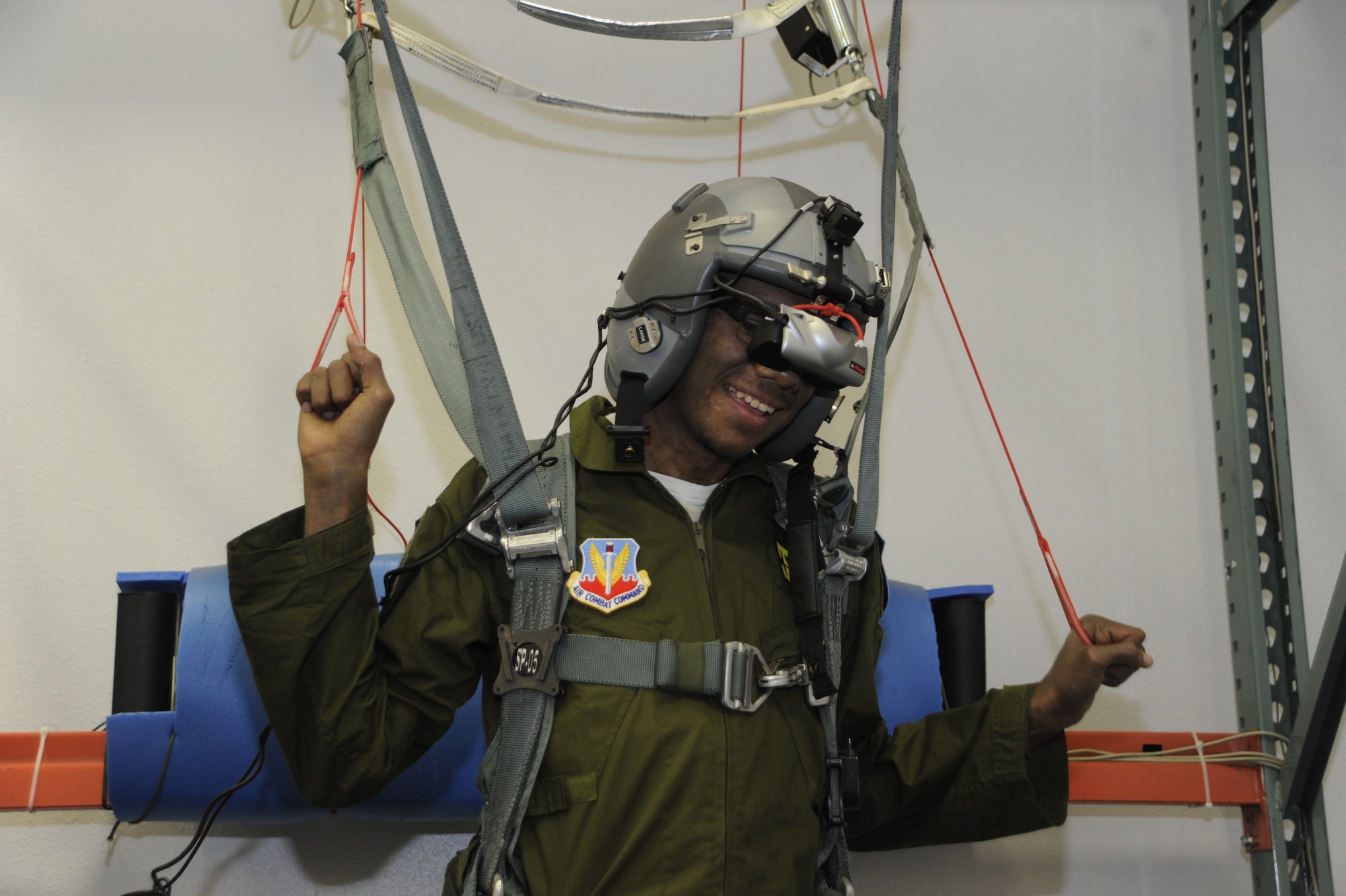Sergio Quiroz, an honorary pilot with the 357th Fighter Squadron, tests out a parachute simulator during his Pilot for a Day program tour at Davis-Monthan Air Force Base, Ariz., Dec. 4, 2014. During the visit, Quiroz was inducted into the 357th FS where him and his cousins tried on pilot flight equipment, visited the A-10 and parachute simulators and toured the air traffic control tower. (U.S. Air Force photo by Airman 1st Class Betty R. Chevalier)