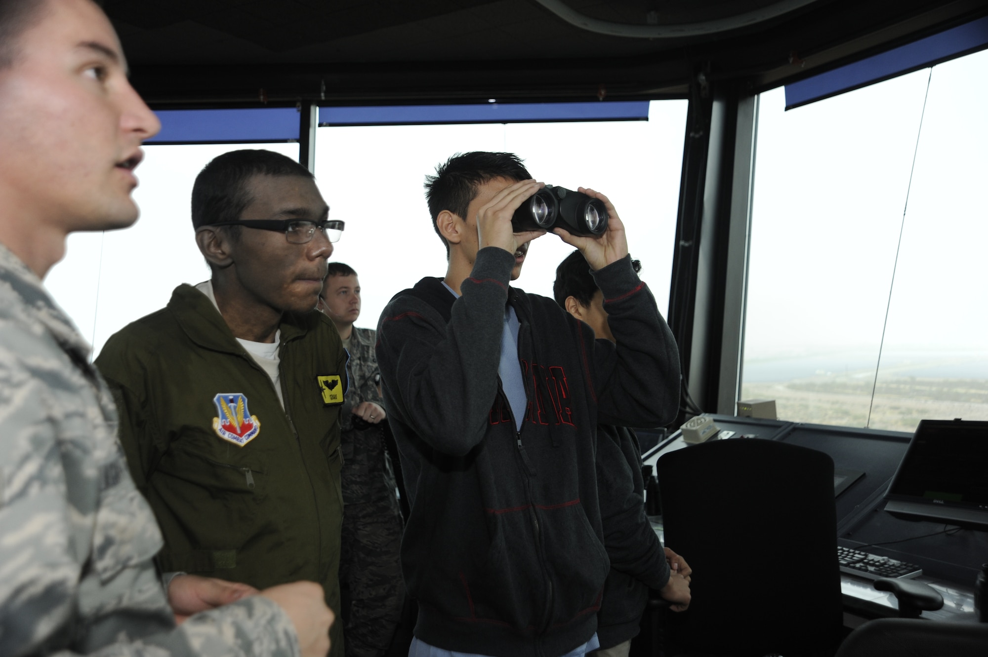 Alexander Cano observes the flightline through binoculars during a tour with his cousin, Sergio Quiroz who was inducted into the 357th Fighter Squadron for the Pilot for a Day program at Davis-Monthan Air Force Base, Ariz., Dec. 4, 2014. During the visit, Quiroz was inducted into the 357th FS where him and his cousins tried on pilot flight equipment, visited the A-10 and parachute simulators and toured the air traffic control tower. (U.S. Air Force photo by Airman 1st Class Betty R. Chevalier)