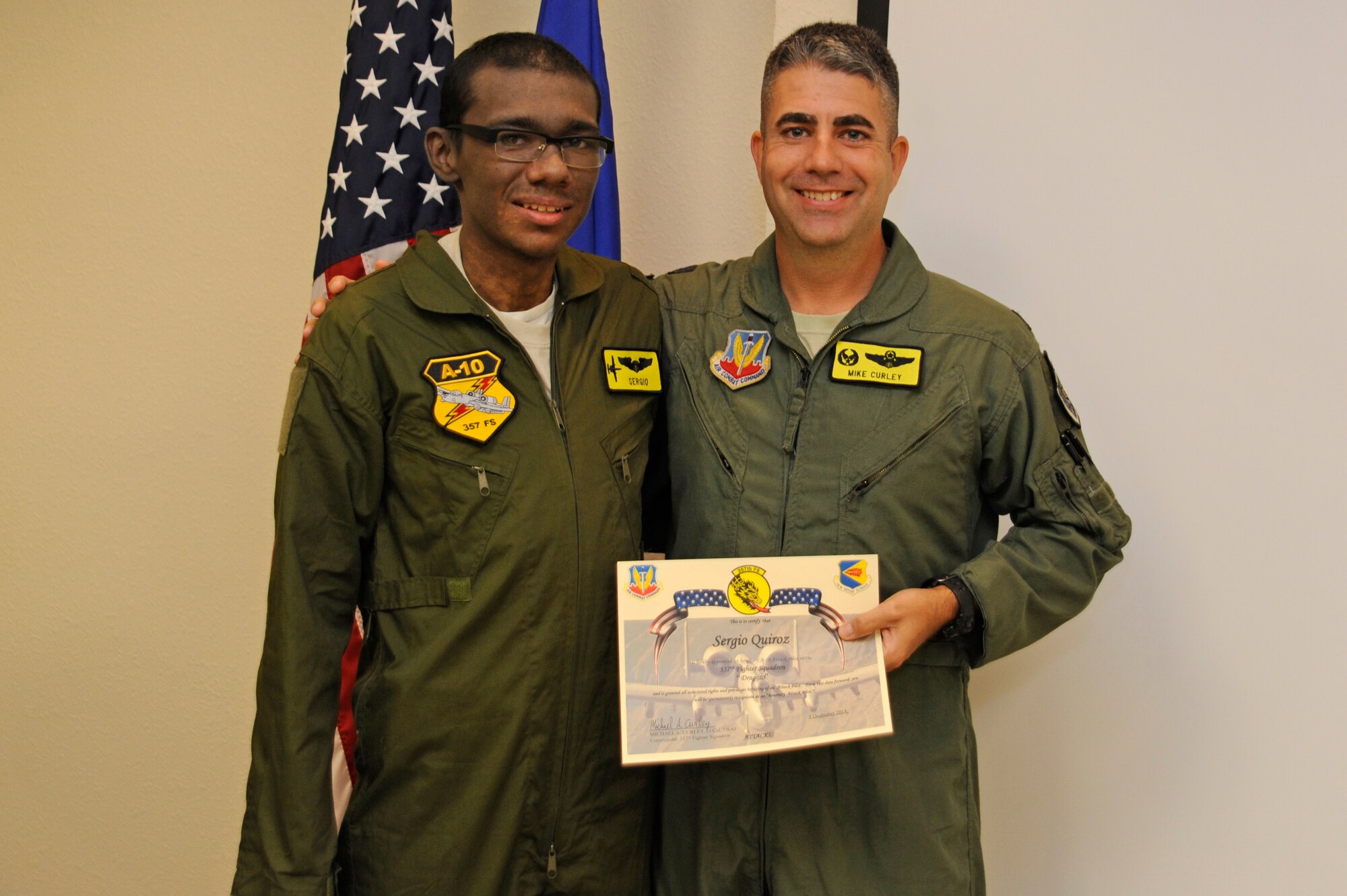 Sergio Quiroz and U.S. Air Force Lt. Col. Michael Curley, 357th Fighter Squadron commander, pose for a photo after Quiroz was sworn in as an honorary pilot during the Pilot for a Day program at Davis-Monthan Air Force Base, Ariz., Dec. 4, 2014. During the visit, Quiroz was inducted into the 357th FS where him and his cousins tried on pilot flight equipment, visited the A-10 and parachute simulators and toured the air traffic control tower. (U.S. Air Force photo by Airman 1st Class Betty R. Chevalier)
