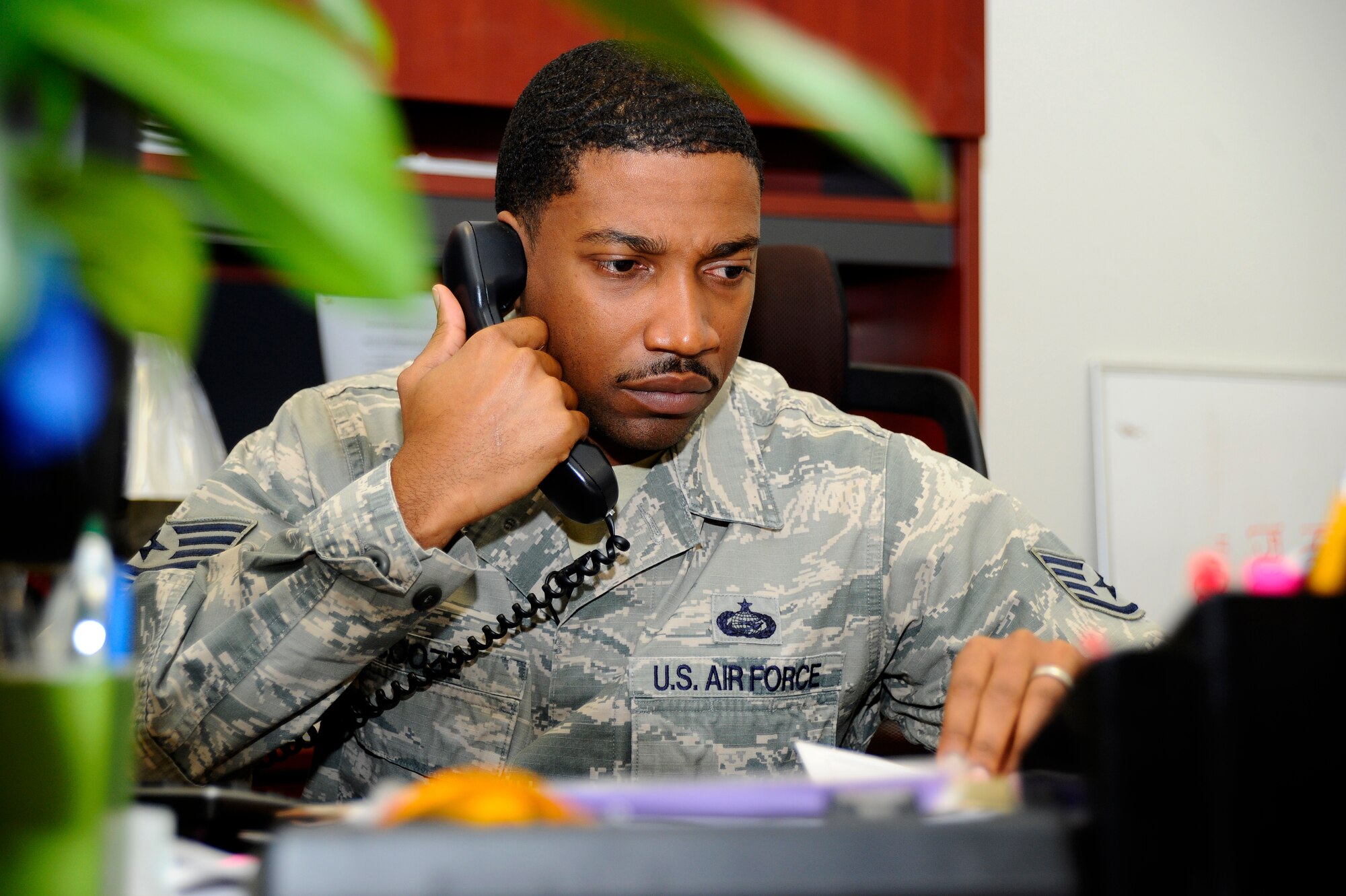 Staff Sgt. Keith J. Booze, 22nd Force Support Squadron military personnel section customer support NCO in charge, listens to a customer on the phone, Dec. 9, 2014, at McConnell Air Force Base, Kan. Booze was selected as the Wichita Red Cross Spirit Aerosystems 2014 Military Hero after saving a young girl from drowning earlier this year. (U.S. Air Force photo/Senior Airman Victor J. Caputo)