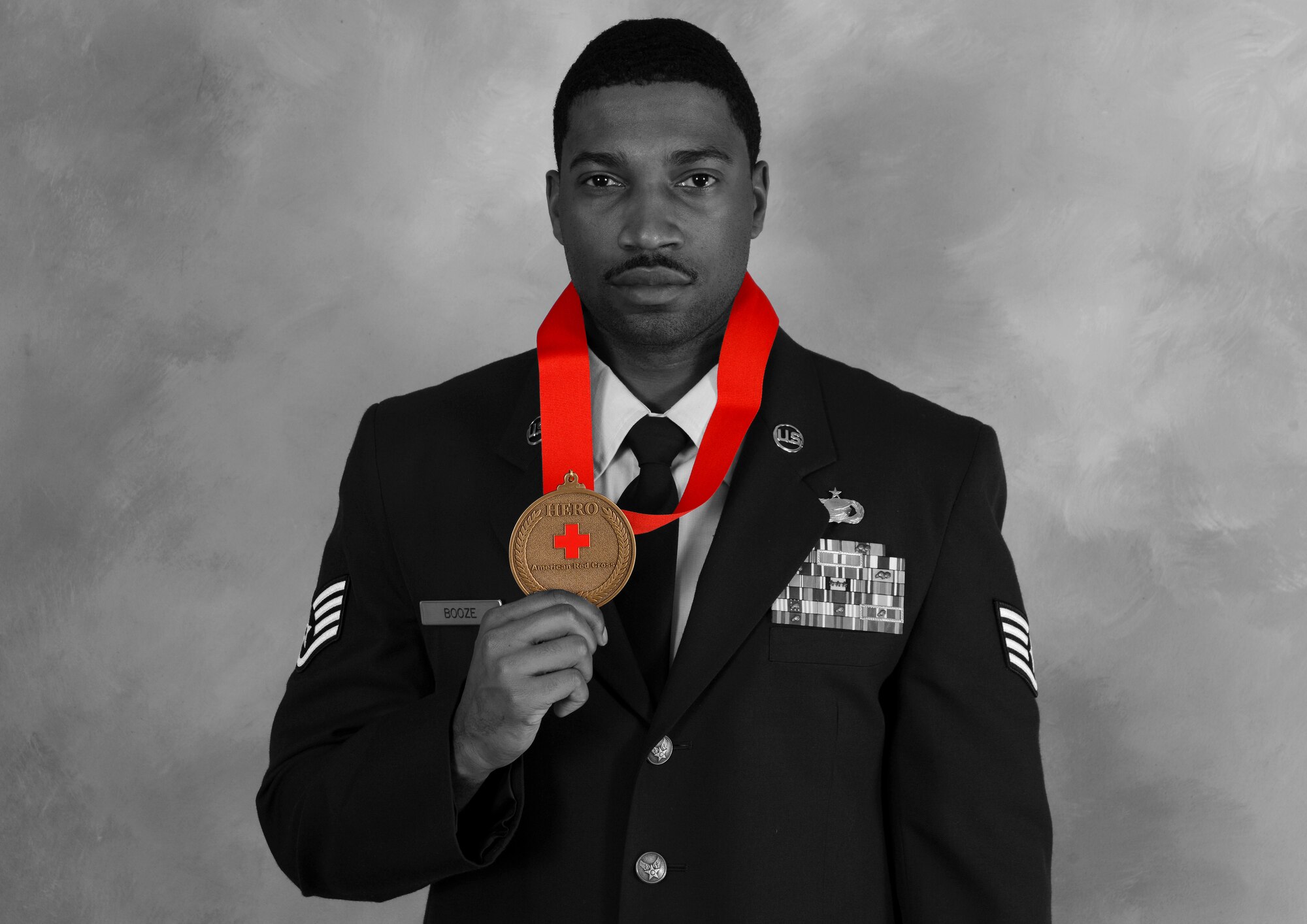 Staff Sgt. Keith J. Booze, 22nd Force Support Squadron military personnel section customer support NCO in charge, poses with his Red Cross medal, Dec. 10, 2014, at McConnell Air Force Base, Kan. Booze was selected for the Wichita Red Cross Spirit Aerosystems 2014 Military Hero after he saved a young girl from downing at a local YMCA. (U.S. Air Force photo illustration/Senior Airman Victor J. Caputo)