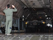 The driver, Staff Sgt. Ryan Dane, 73rd Aerial Port Squadron ramp agent, navigates a Tunner 60k aircraft cargo loader/transporter, never before available to the 73 APS Airmen, off the ramp onto Naval Air Station Fort Worth Joint Reserve Base, Texas, Dec. 6, 2014. This machine, borrowed from the 502nd Logistics Readiness Squadron, Joint Base San Antonio, Texas, and delivered on a 433rd Airlift Wing C-5, gave crucial operational training to nearly 30 aerial port Airmen. (U.S. Air Force photo by Master Sgt. Julie Briden-Garcia)