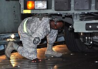 Senior Master Sgt. Steve Turner, 73rd Aerial Port Squadron ramp superintendent, takes one last safety check prior to unloading the Tunner 60k aircraft cargo loader/transporter at Naval Air Station Fort Worth Joint Reserve Base, Texas, for a historic training opportunity Dec. 6, 2014.  The machine, borrowed from the 502nd Logistics Readiness Squadron, Joint Base San Antonio, Texas, and delivered on a 433rd Airlift Wing C-5, gave nearly 30 aerial port Airmen crucial combat operational training requirements that are crucial prior to a deployment. (U.S. Air Force photo by Master Sgt. Julie Briden-Garcia) 
