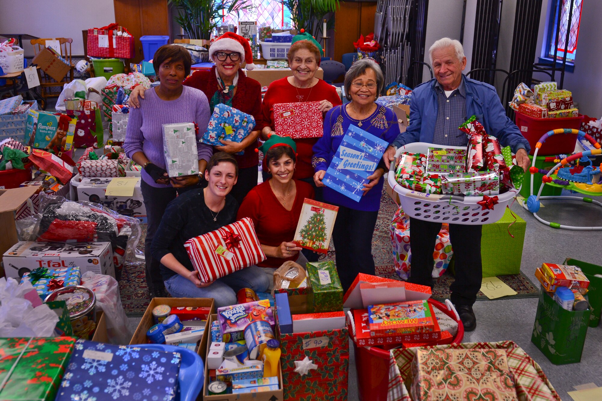 Volunteers hold gifts for Operation True Giving families at the Palmetto Chapel at Shaw Air Force Base, S.C., Dec. 5, 2014. Operation True Giving is an outreach program which is designed to help military families and the Sumter community every holiday season giving gifts and food. (U.S. Air Force photo by Senior Airman Tabatha Zarrella/Released)