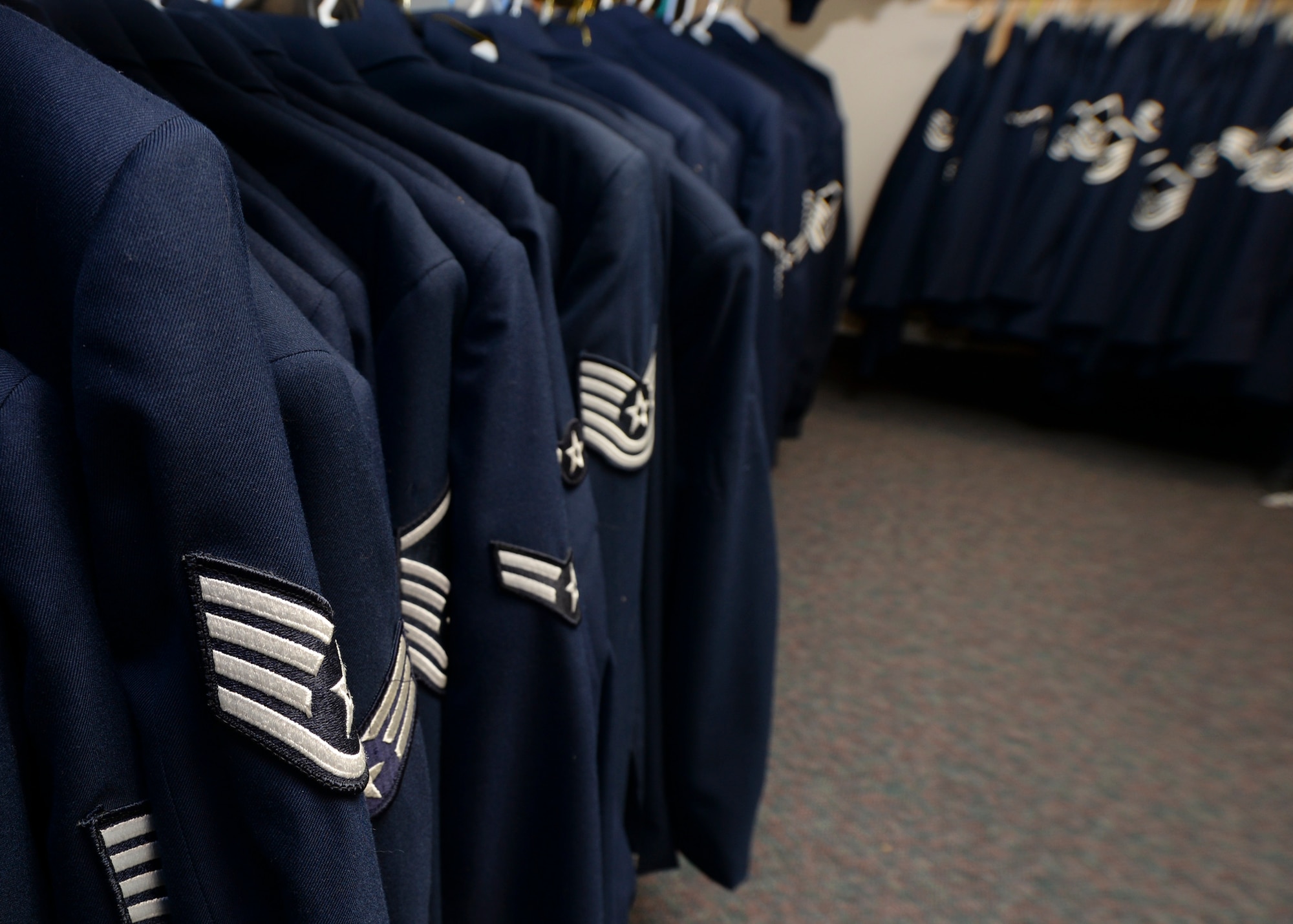 Service Blues uniforms ranging from service coats and blues shirts to mess dress and trench coats line the walls inside the Diamond Mart at Ellsworth Air Force Base, S.D., Dec. 4, 2014. Airmen are encouraged to visit the facility should they be in need of any uniform items. (U.S. Air Force photo by Senior Airman Anania Tekurio/Released)