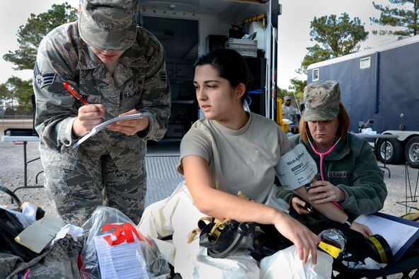 U.S. Air Force Senior Airman Chantal Hogue, 20th Civil Engineer Squadron emergency management apprentice, has her vital signs taken by 20th Aerospace Medicine Squadron medical technicians during an integrated base emergency response capability training exercise at Shaw Air Force Base, S.C., Dec. 9, 2014. Before suiting up in contamination gear, each of the three Airmen who were a part of the initial entry team had their vital signs taken before and after walking through the contaminated area. (U.S. Air Force photo by Airman 1st Class Jensen Stidham/Released) 