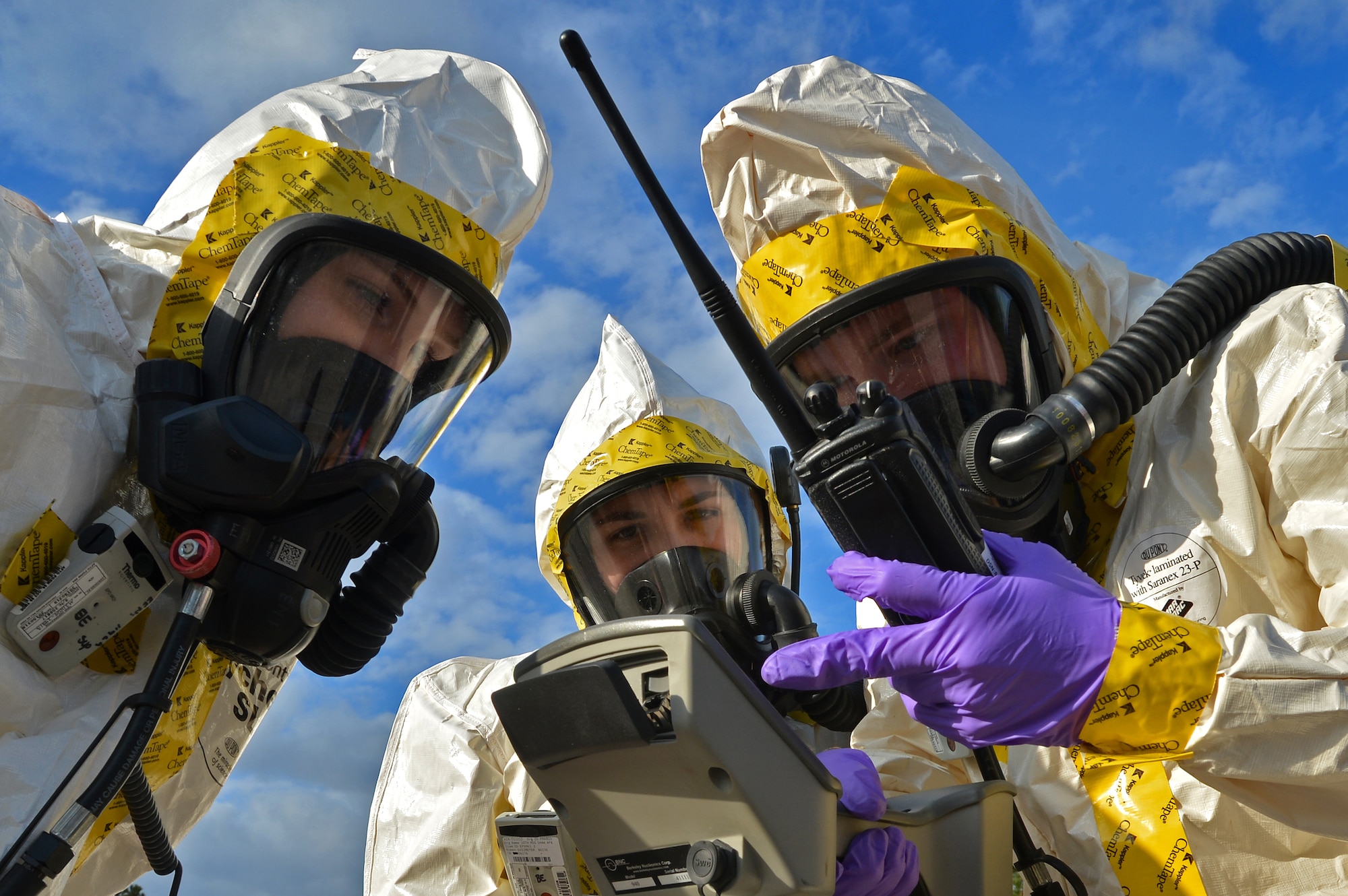 (From left) U.S. Air Force Senior Airman Lauren Yancey, and Chantal Hogue, 20th Civil Engineer Squadron emergency management apprentices, and Senior Airman Jordan Gagne, 20th Aerospace Medicine Squadron bioenvironmental engineering journeyman, assess their gages while checking for simulated hazardous chemicals during an integrated base emergency response capability training at Shaw Air Force Base, S.C., Dec. 9, 2014. The Airmen worked together to assess the spread of simulated chemicals while being evaluated on their performance. (U.S. Air Force photo by Staff Sgt. Kenny Holston/Released)      