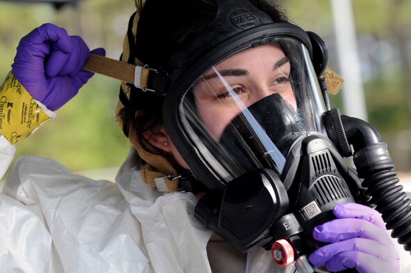 U.S. Air Force Senior Airman Chantal Hogue, 20th Civil Engineer Squadron emergency management apprentice, adjusts her mask during an integrated base emergency response capability training at Shaw Air Force Base, S.C., Dec. 9, 2014. During the exercise, Hogue and two other Airmen acted as the initial entry team in response to a simulated chemical attack. (U.S. Air Force photo by Airman 1st Class Michael Cossaboom/Released) 
