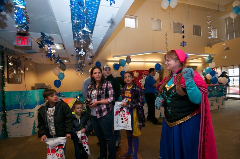 Elsa greets family members during the Children’s Holiday Festival Dec. 6, 2014, at Schriever Air Force Base, Colo. The event featured four bounce castles, face painting and a meet-and-greet with Santa Claus as well as a complimentary lunch. (Air Force Photo/Senior Airman Naomi Griego)