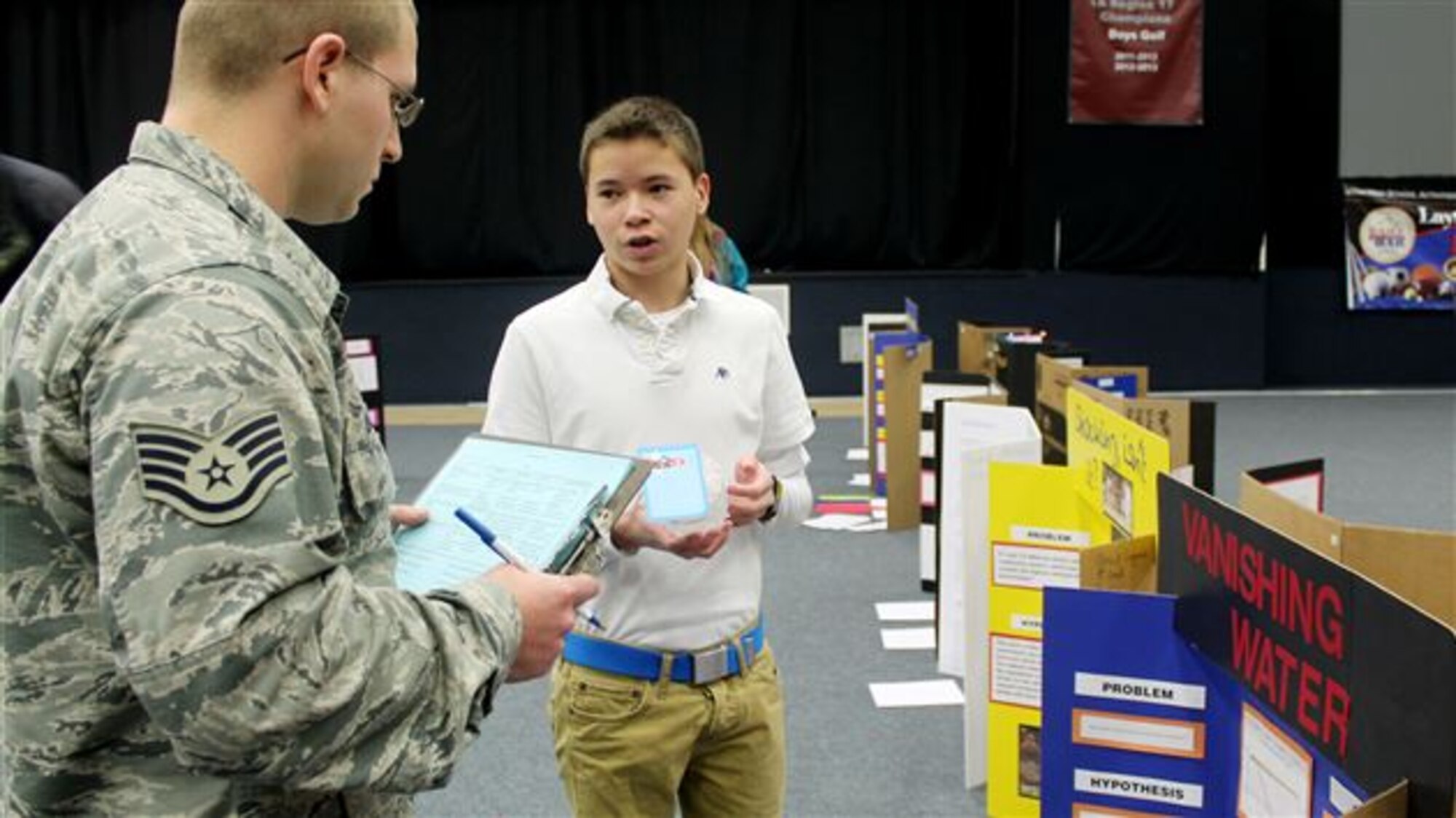 Chase Uragami, ninth-grader at Layton Christian Academy, presents his science fair project on Dec. 8 to Staff Sgt. Travis Laughlin who helped volunteer for the fair. (Photo by Dana Rimington)