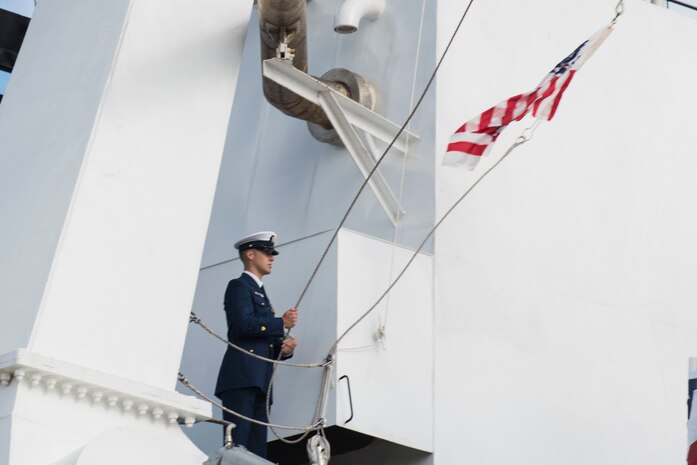 A crew member of Coast Guard Cutter Hamilton raises the Coast Guard ensign and commissioning pennant for the first time aboard the new cutter as part of a commissioning ceremony in Charleston, Dec. 6, 2014. Hamilton is the Coast Guard’s fourth 418-foot Legend-Class National Security Cutter. (Coast Guard photo by Petty Officer 1st Class Stephen Lehmann)