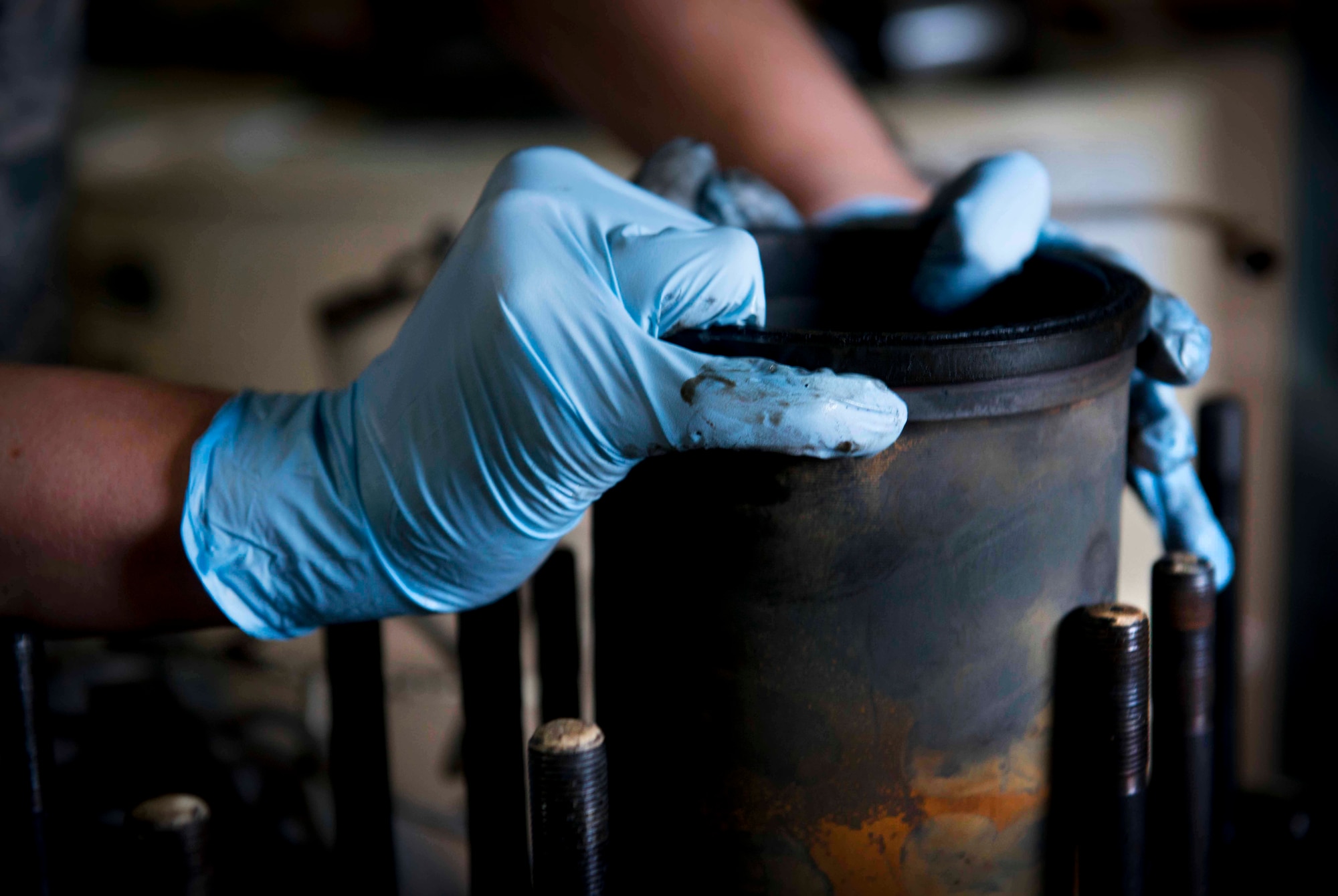 Airman 1st Class Tom Bozeman, 91st Missile Maintenance Squadron facilities maintenance section technician, removes a cylinder sleeve from an engine block on Minot Air Force Base. N.D., Nov. 25, 2014. The defense reutilization and marketing office section is responsible for taking unneeded military assets and revitalizing them for use elsewhere. (U.S. Air Force photo/Airman 1st Class Sahara L. Fales)
