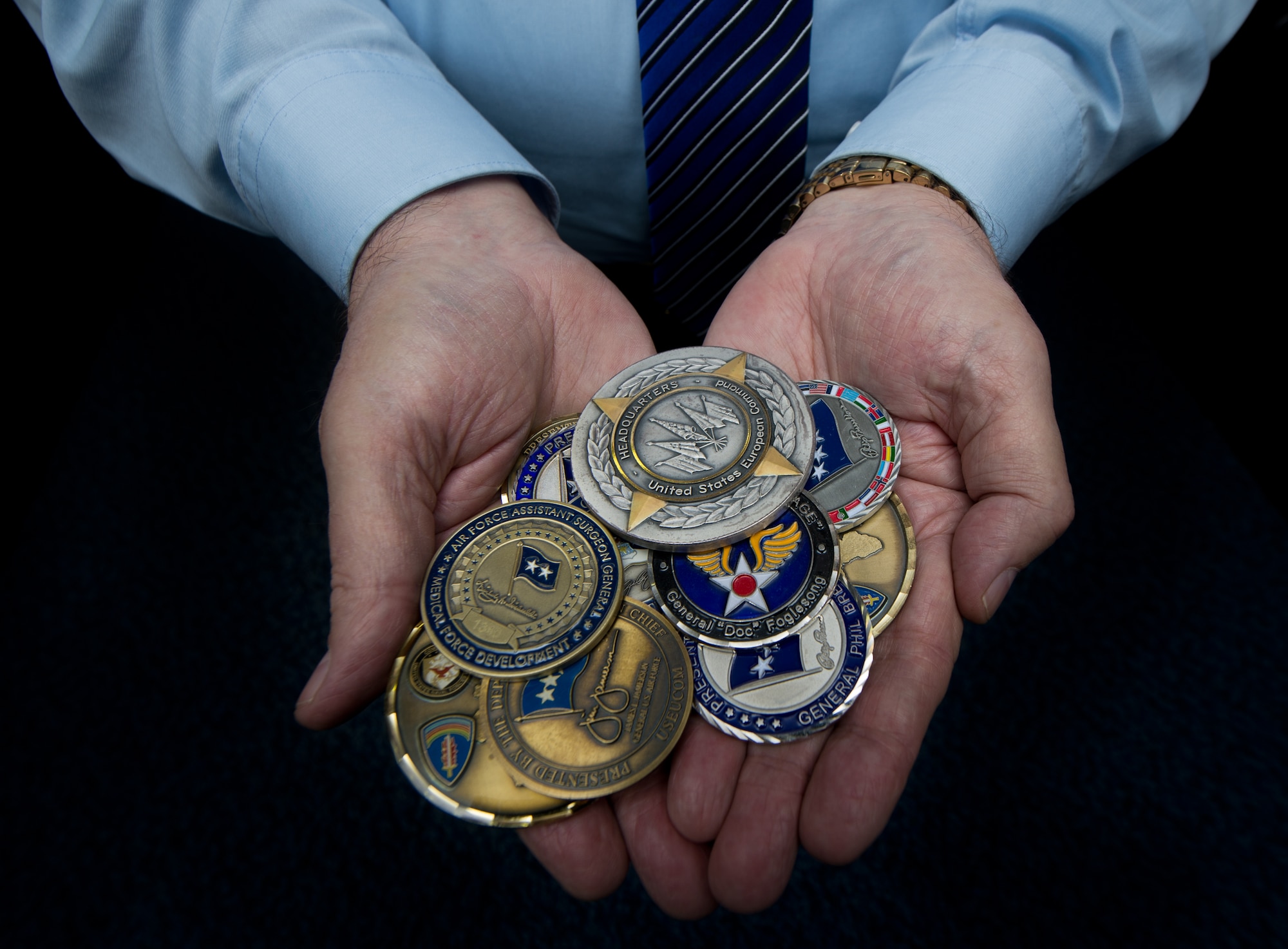 John Mace, 86th Medical Group special operations medical officer, holds a handful of coins he has collected throughout his 54 years in the military, Dec. 8, 2014, at Ramstein Air Base. Mace is scheduled to retire Dec. 12, 2014, after spending 25 years in active duty and 29 more in civil service. While at the 86th MDG, Mace directly supported commanders in one of the Air Force’s largest ambulatory-care facilities outside the U.S. (U.S. Air Force photo/Senior Airman Jonathan Stefanko)