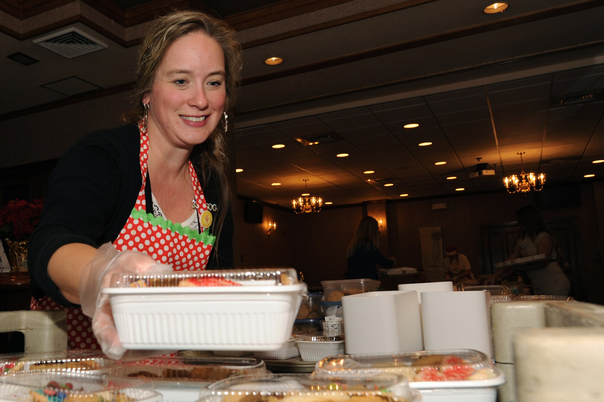 Rachel Trube, a cookie drive volunteer, places a box of cookies on a tray during the holiday cookie drive on Kadena Air Base, Japan, Dec. 9, 2014. More than 50 volunteers from several base agencies helped pack the cookies into individual portions and deliver them to approximately 2,100 Airmen, soldiers, sailors and Marines living in dormitories on Kadena. (U.S. Air Force photo by Airman 1st Class Zade C. Vadnais/Released)