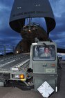 Staff Sgt. Ryan Dane, 73rd Aerial Port Squadron, offloads a Tunner 60k aircraft cargo loader/transporter never before available to the unit providing them a historical training opportunity at Naval Air Station Fort Worth Joint Reserve Base, Texas, Dec. 6, 2014. The 433rd Airlift Wing C-5 from Joint Base San Antonio, Texas, delivered the 60k loader, borrowed from JBSA's 502nd Logistics Readiness Squadron, giving nearly 30 of the 73 APS Airmen combat operational training requirements that are crucial prior to a deployment. (U.S. Air Force photo by Master Sgt. Julie Briden-Garcia)
