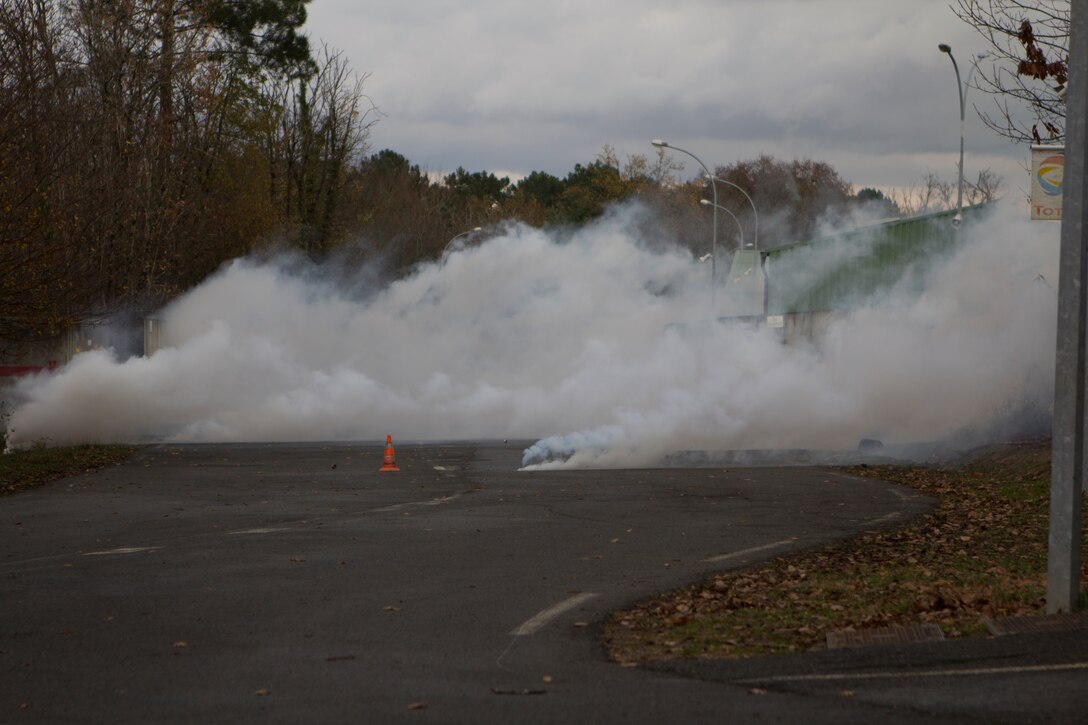 Tear gas fills the streets after U.S. Marines with SPMAGTF Crisis Response – Africa, fire Cougar grenade launchers at the National Gendarmerie Training Center in St. Astier, France, Dec. 1, 2014.  The Marines were conducting crowd and riot control training with the French Gendarmerie, allowing the Marines to gain greater knowledge of non-lethal tactics, techniques and procedures while enhancing interoperability with the French Gendarmerie and strengthening the U.S. partnership with France.  (U.S. Marine Corps photo by Cpl. Jeraco Jenkins/Released).