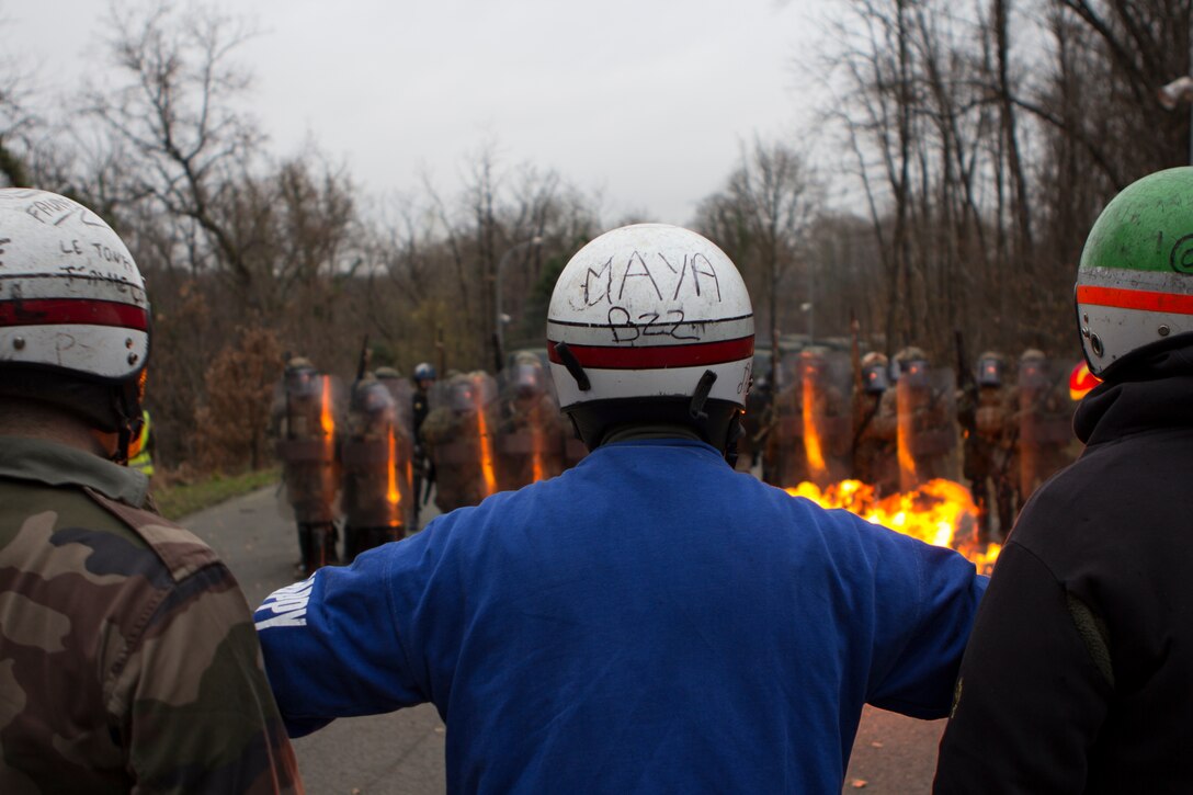 Mock rioters attempt to block U.S. Marines with SPMAGTF Crisis Response – Africa and French gendarmes with Mobile Gendarmeries Armored Group, as they train in crowd and riot control techniques at the National Gendarmerie Training Center in St. Astier, France, Dec. 2, 2014. The exercise allowed the Marines to gain greater knowledge of non-lethal tactics, techniques and procedures while enhancing interoperability with the French Gendarmerie and strengthening the U.S. partnership with France. (U.S. Marine Corps photo by Cpl Jeraco Jenkins/Released)