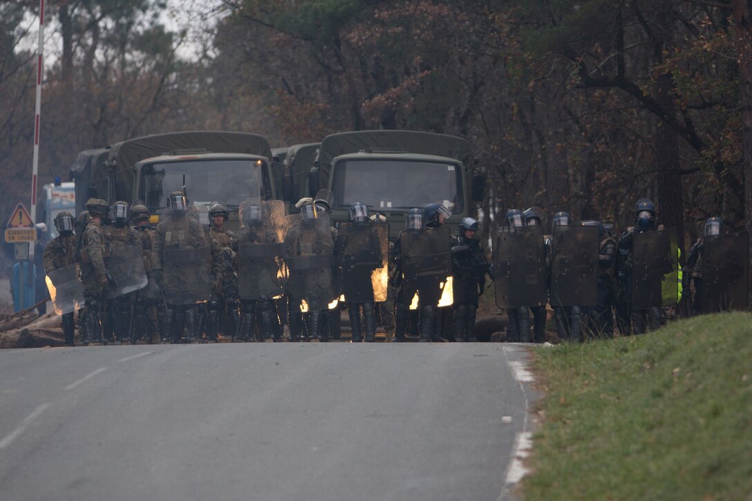U.S. Marines with SPMAGTF Crisis Response – Africa and French gendarmes with Mobile Gendarmeries Armored Group work together to control a mock riot caused by role-players, while training in crowd and riot control techniques at the National Gendarmerie Training Center in St. Astier, France, Dec. 3, 2014. The exercise allowed the Marines to gain greater knowledge of non-lethal tactics, techniques and procedures while enhancing interoperability with the French Gendarmerie and strengthening the U.S. partnership with France. (U.S. Marine Corps photo by Cpl Jeraco Jenkins/Released).