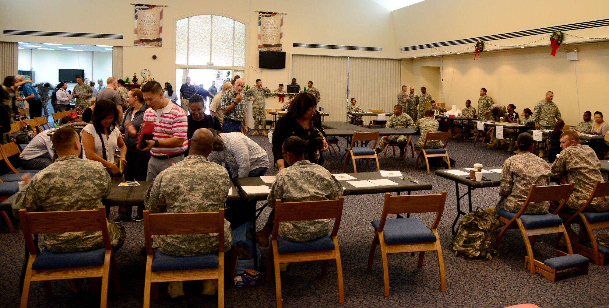 U.S. Air Force and Army personnel process family members through the evacuation center during a Noncombatant Evacuation Operations exercise, Dec. 6, 2014, at Camp As Sayliyah, Qatar. NEO exercises help prepare families, train military members and refine the planning of a full-scale evacuation order from the U.S. Department of State. (U.S. Air Force photo by Senior Airman Kia Atkins)