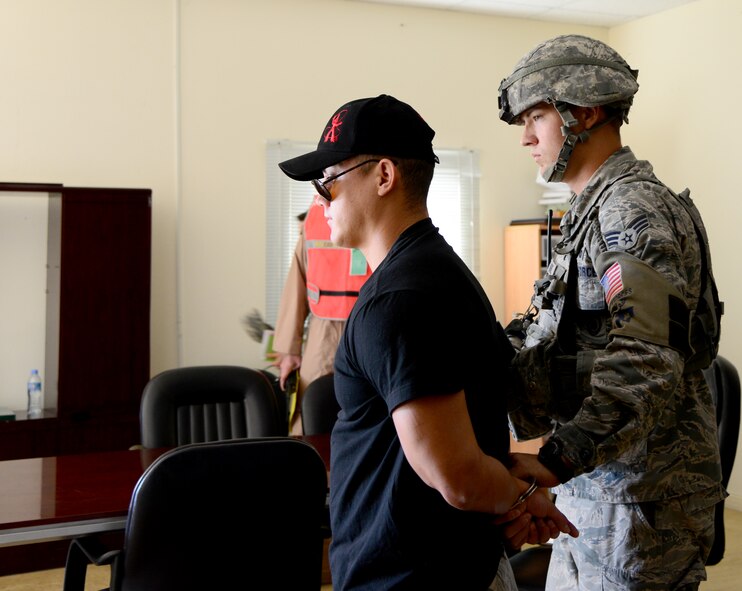 U.S. Air Force Senior Airman Joshua Gomez, 379th Expeditionary Security Forces Squadron, apprehends  a simulated gunman  during an active shooter exercise, Dec. 10, 2014, at Al Udeid Air Base, Qatar. Gomez is deployed from Charleston Air Force Base, S.C. Once the primary simulated threat was removed, 379th ESFS Airmen performed a hallway and room check to verify no secondary threats were present. (U.S. Air Force photo by Senior Airman Kia Atkins)