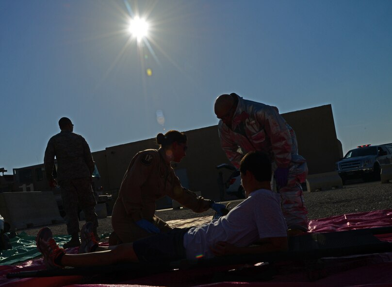 First responders provide aid to simulated victims during an active shooter exercise, Dec. 10, 2014, at Al Udeid Air Base, Qatar. During the exercise, the 379th Air Expeditionary Wing security forces Airmen, firefighters and medical personnel were evaluated on their response capabilities to a violent incident. (U.S. Air Force photo by Senior Airman Kia Atkins)