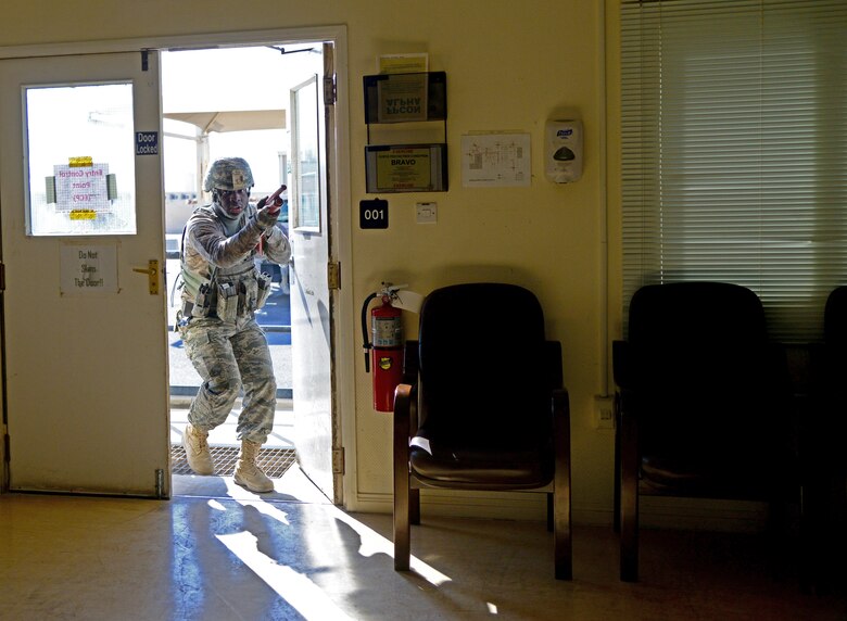 U.S. Air Force Senior Airman Brandon Rivers, 379th Expeditionary Security Forces Squadron, enters a building to search for a simulated gunman during an active shooter exercise, Dec. 10, 2014, at Al Udeid Air Base, Qatar. Rivers is deployed from Charleston Air Force Base, S.C. Airmen from the 379th ESFS are responsible for clearing a building during an active shooter exercise to remove the threat, allowing medical personnel to respond to simulated wounded inside. (U.S. Air Force photo by Senior Airman Kia Atkins) 