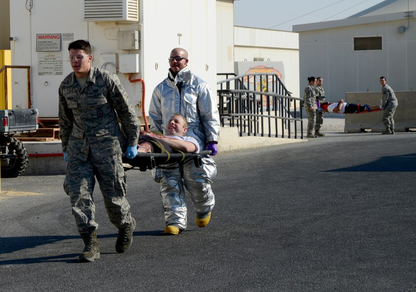 First responders carry simulated victims during an active shooter exercise outside to be triaged, Dec. 10, 2014, at Al Udeid Air Base, Qatar. Active shooter exercises help prepare Airmen to deter, detect and defeat insider threats by increasing their awareness, vigilance and resiliency through initial and recurring training. (U.S. Air Force photo by Senior Airman Kia Atkins)